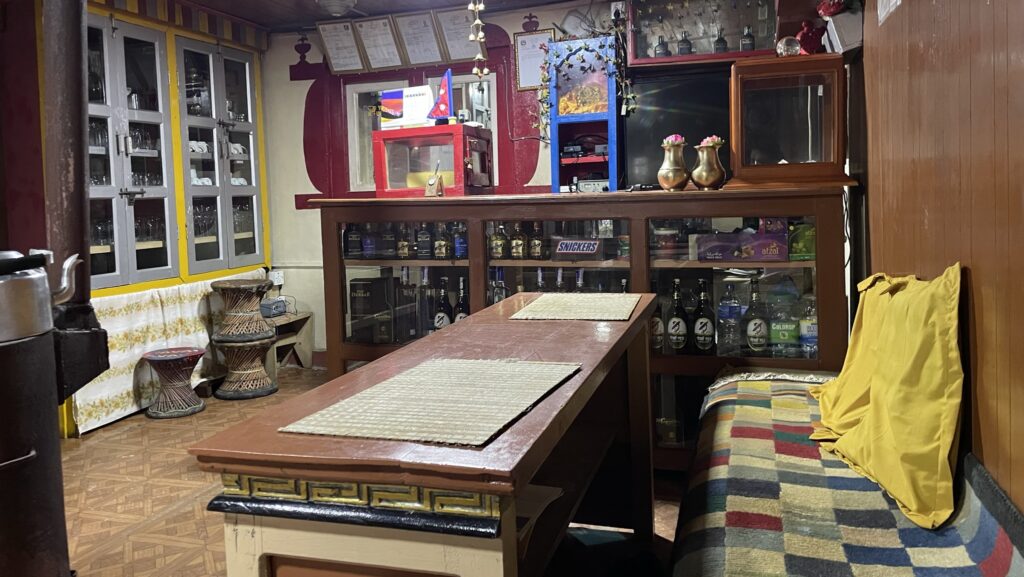 Interior of dining room in teahouse Nepal with a table, counter, and bench to sit on