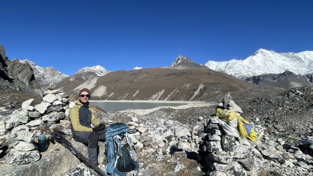 Hiker sitting at a lake towards Cho Oyu base camp